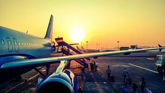 Vliegtuig bij zonsondergang — luchthavenvervoer met B&R Taxi